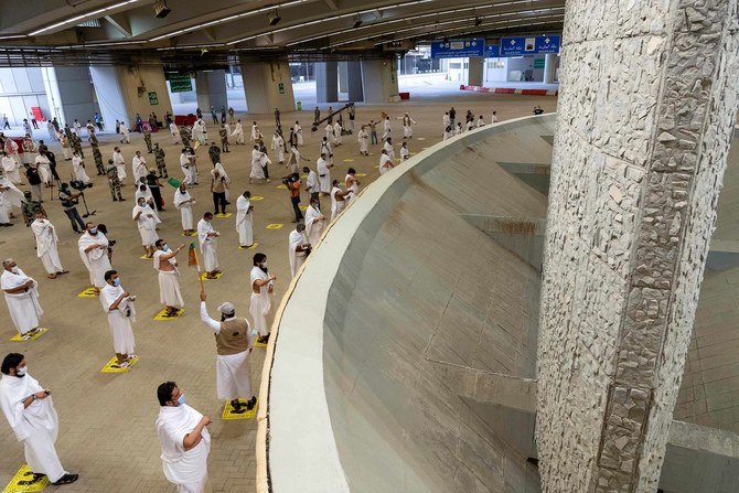 Pilgrims, maintaining strict social distancing regulations, throw pebbles on Friday at Jamarat Al-Aqabah during the symbolic Stoning of the Devil ritual. (SPA)
