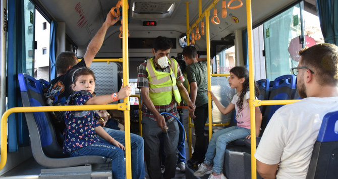 A Syrian municipality worker disinfects a bus in the northern city of Aleppo. (AFP)