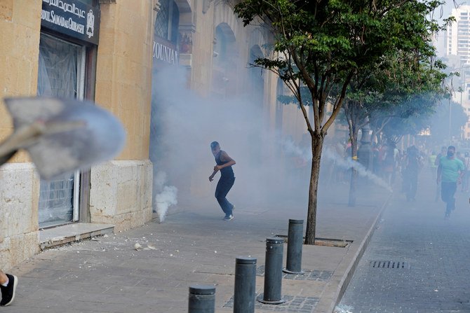Demonstrators run away from tear gas fired by riot police near the parliament building during a protest following Tuesday's blast, in Beirut, Lebanon August 8, 2020. (Reuters)