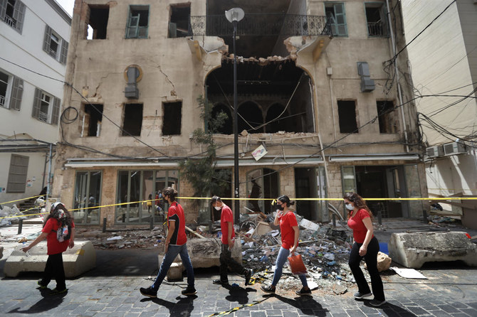 University students who volunteered to help clean damaged homes and give other assistance, pass in front of a building that was damaged by last week’s explosion, in Beirut, Lebanon, Tuesday, Aug. 11, 2020. (AP)