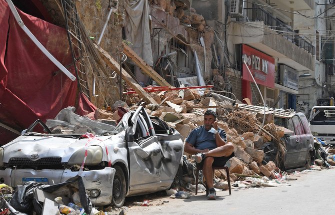 A man talks on the phone while seated by the rubble of a destroyed traditional building in the Gemmayzeh neighborhood after a cataclysmic port explosion which devastated Lebanon's capital Beirut. (AFP/File Photo)