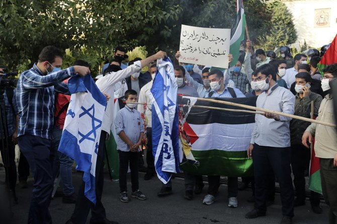 A group of protesters burn representations of Israeli flag during a gathering outside the United Arab Emirates' embassy in Tehran on Aug. 15, 2020, to condemn the UAE's historic deal with Israel to open up diplomatic relations. (AP Photo/Ebrahim Noroozi)