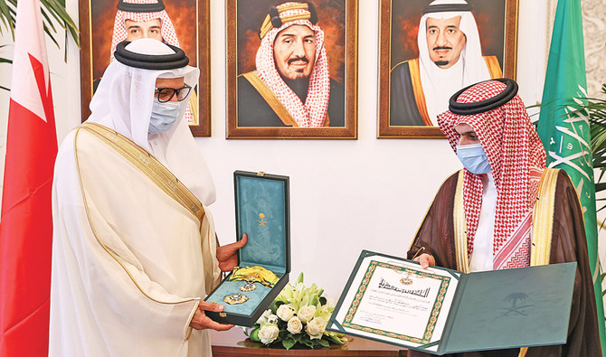 Saudi Foreign Minister Prince Faisal bin Farhan, right, presents his Bahraini counterpart the King Abdul Aziz Sash of the second degree in Riyadh. (SPA)