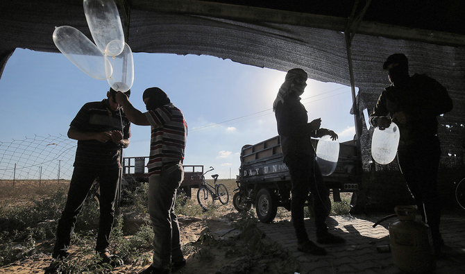 Palestinians prepare incendiary devices attached to inflated condoms to be directed and flown towards Israel, near Rafah along the border between the Gaza Strip and Israel on August 21, 2020. (AFP)