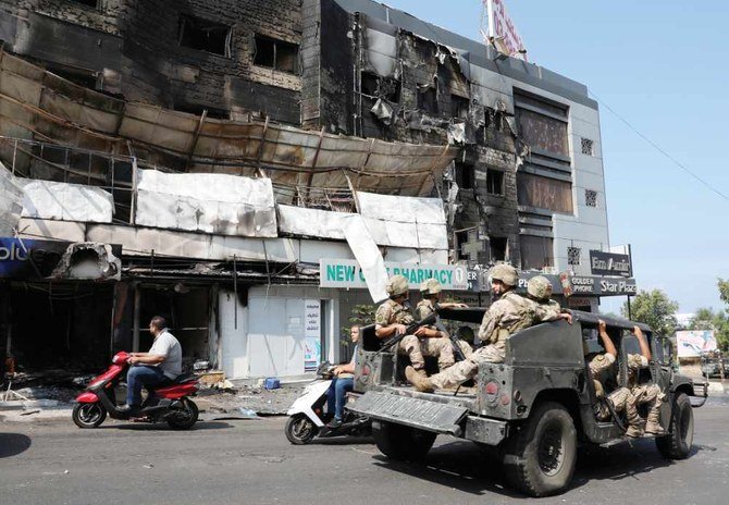 Lebanese soldiers in Khaldeh patrol near burned shops in the aftermath of clashes. (Reuters)