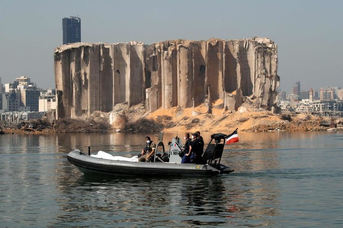 Members of the Lebanese army and the French military ride in a zodiac past the damaged grain silo at the site of the massive blast in Beirut's port area. (AFP)