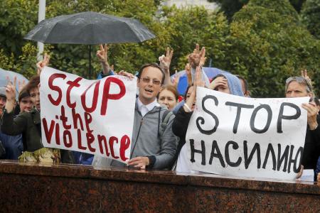 Protesters with posters reading