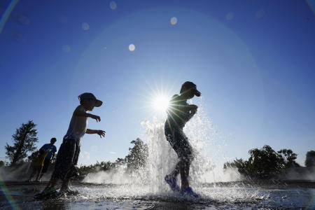 Children play with water at a park in Isezaki, Gunma prefecture, Japan. The city recorded over 40 degrees Celsius (104 degrees Fahrenheit) Tuesday, according to Japan Meteorological Agency. (Kyodo News via AP)