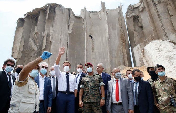 Macron, surrounded by Lebanese servicemen, visits the devastated site of the explosion at the port of Beirut. (AFP)