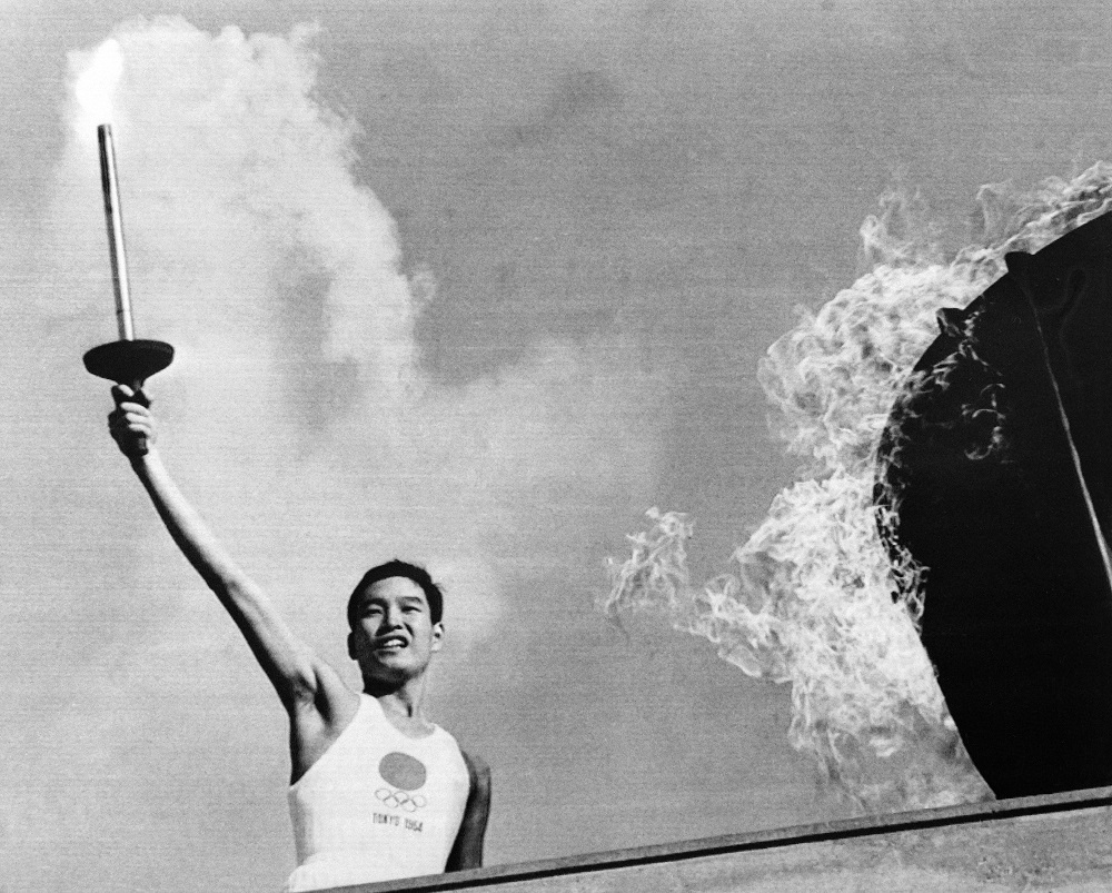Picture taken on October 10, 1964 shows Japanese Olympic torch runner Yoshinori Sakai lighting the Olympic torch during the opening ceremony of the 1964 Tokyo Olympic Games. (AFP/file)