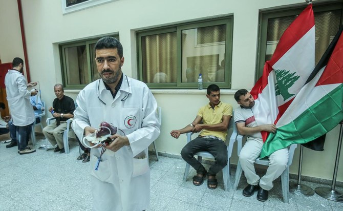 Palestinians donate blood during an event organized by the municipality, the Red Crescent, and the Ministry of Health in Khan Yunis in the southern Gaza Strip, on August 5, 2020, in support of Lebanon in the aftermath of a massive explosion which rocked its capital. (AFP)