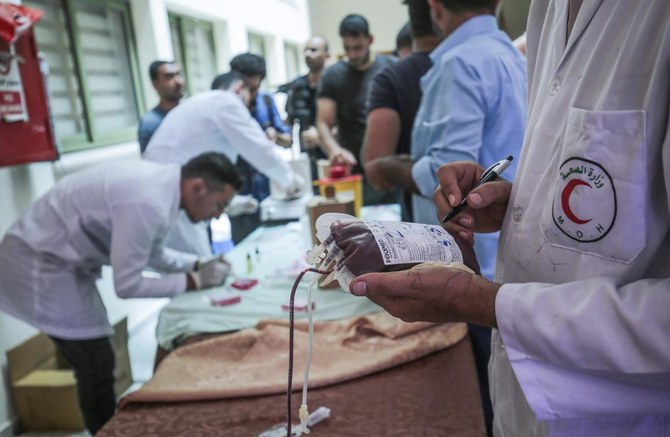 Palestinians donate blood during an event organized by the municipality, the Red Crescent, and the Ministry of Health in Khan Yunis in the southern Gaza Strip, on August 5, 2020, in support of Lebanon in the aftermath of a massive explosion which rocked its capital. (AFP)