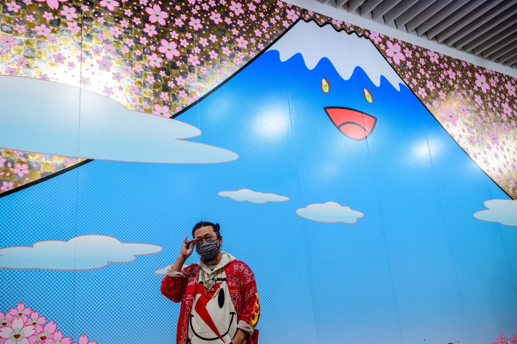 Artist Takashi Murakami stands in front of his work 