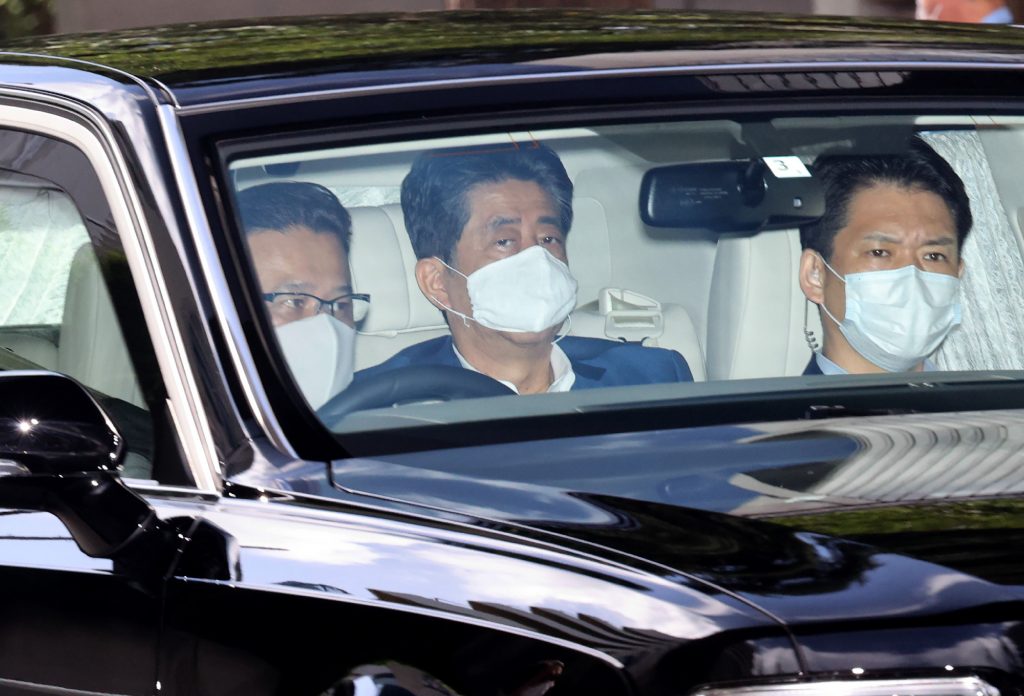 Japan's Prime Minister Shinzo Abe (C) arrives at a hospital in Tokyo on August 24, 2020. (AFP)