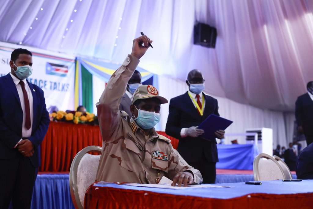 Lieutenant general Mohamed Hamdan Dagalo of Sudan holds up a pen before signing the peace deal document between the government and the rebel groups during the singing of the Sudan peace deal with the rebel in Juba, South Sudan, on August 31, 2020. (AFP)