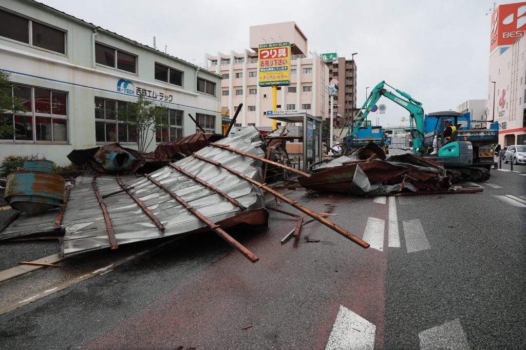 A clean-up crew works to remove roofs which were blown off into a street by strong winds brought by Typhoon Haishen in Fukuoka as the storm passes the southern Japanese island of Kyushu on September 7, 2020. (AFP)