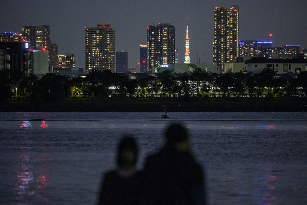 The Tokyo Tower (C) is seen lit up alongside the skyline of the city in Tokyo on September 27, 2020. (AFP)