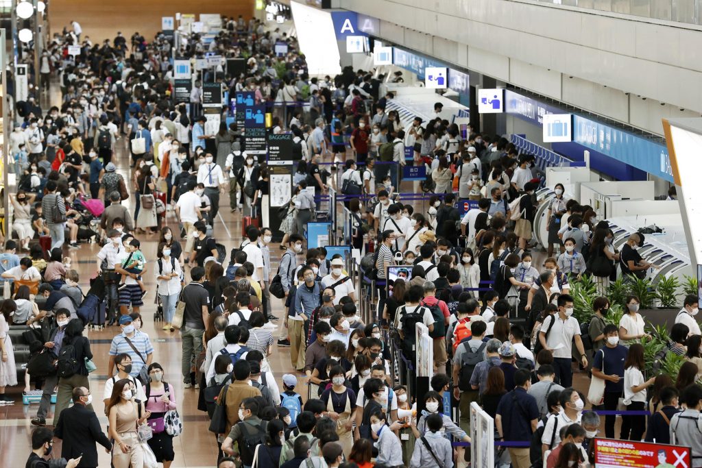 Travelers wearing face masks crowd at Haneda airport in Tokyo Saturday, on the first day of the four-day holiday, Sep. 19, 2020, (File photo/Kyodo News via AP)