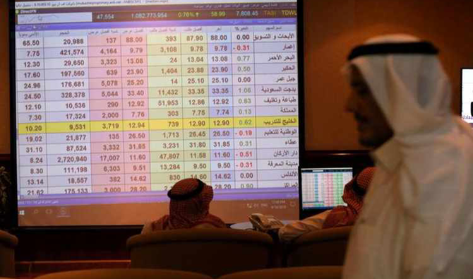 Saudi men inspect a screen showing stock prices at ANB Bank in Riyadh, Saudi Arabia. (Reuters)