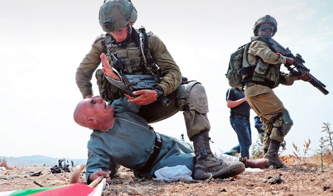 Israeli soldiers hold a Palestinian protester during a demonstration against the Israeli settlement plan, in Tulkarm in the occupied West Bank. (AFP)