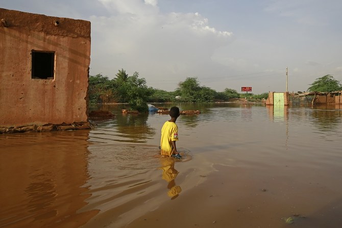 A Sudanese boy wades through a flooded street at the area of al-Qamayir in the capital's twin city of Omdurman, on August 26, 2020. (File/AFP)