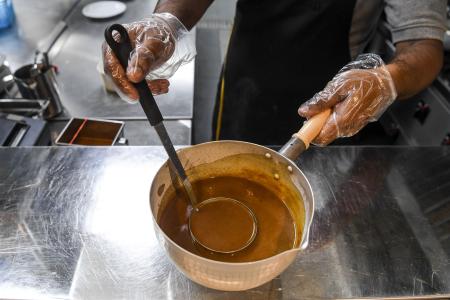 A chef shows a curry made for a customer. 