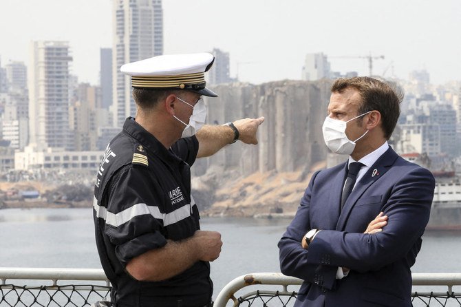 Arnaud Tranchant (left), chief Navy officer for the French helicopter carrier Tonnerre, talks to French President Emmanuel Macron off the port of Beirut, Tuesday, Sept.1, 2020. (AP)