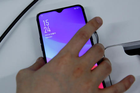 A staff holds a smart phone which is being tested for Rakuten's under-construction mobile network at its network facility in Tokyo, Japan. (Reuters/file)