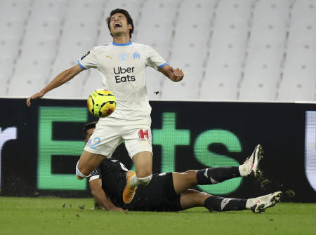 Marseille's Japanese player Hiroki Sakai reacts as he is tackled by a Lille defender during the French League One soccer match between Marseille and Lille at the Stade Velodrome in Marseille, France, Sunday Sept. 20, 2020. (AP)