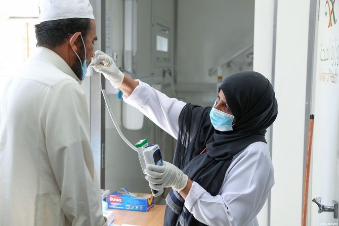 A Saudi nurse checks a patient's temperature at a mobile clinic catering for the residents of Ajyad Almasafi district in the holy city of Mecca. (AFP/file)