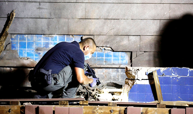 A member of the Israeli security forces checks the scene of an explosion following a rocket attack fired from Gaza, in Ashdod. (Reuters)