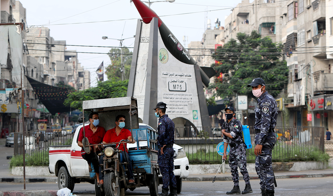 A police officer speaks with men riding an auto rickshaw after Palestinian militant groups and Israel agreed to end an escalation of unrest along the Israel-Gaza border, in Gaza. (Reuters)