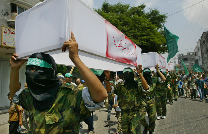 Palestinian members of Hamas carry seven mock coffins of Palestinians who were killed by Israeli troops during clashes in nearby Beit Hanun, during a rally in the Jabalia refugee camp. (File/AFP)