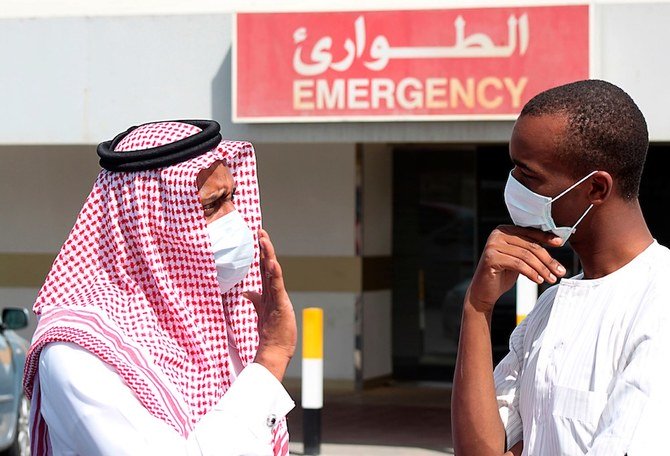 Men wearing surgical masks as a precautionary measure against the novel coronavirus, speak at a hospital in Khobar city in Dammam. (File/Reuters)