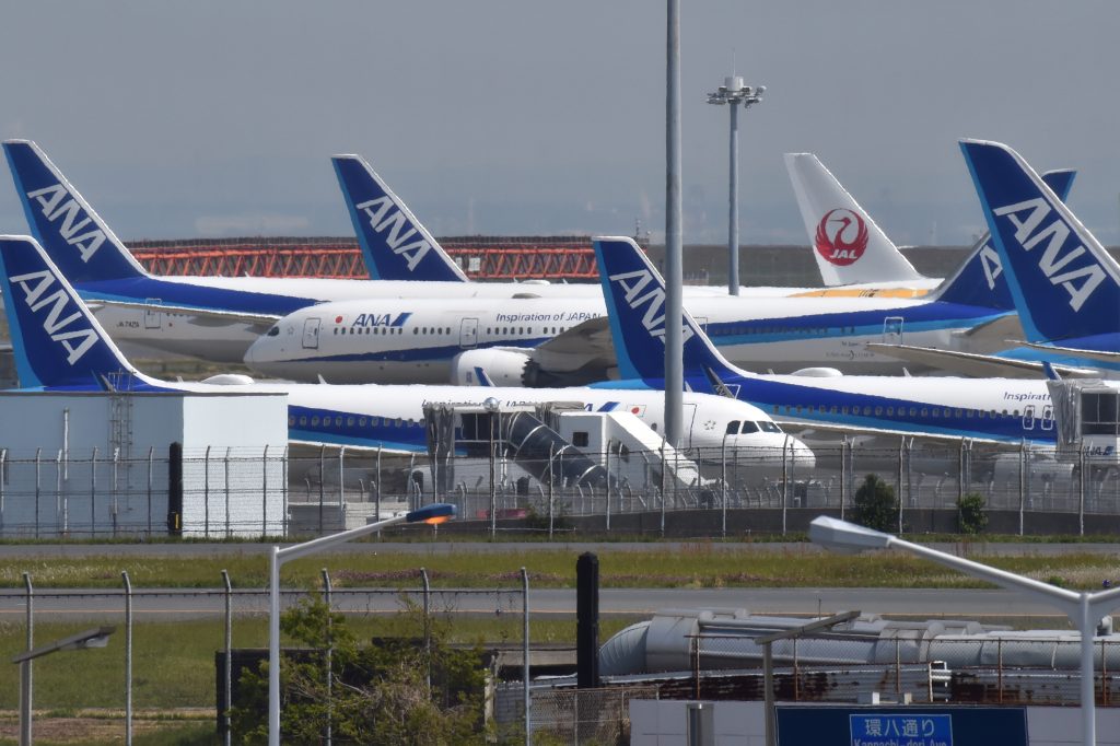 Japan Airlines (JAL) and All Nippon Airways (ANA) passenger planes are parked on the tarmac at Tokyo's Haneda airport on April 28, 2020. (AFP)