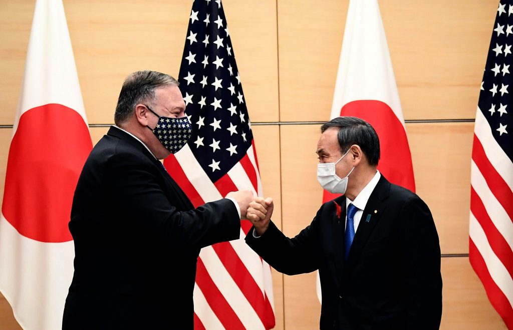 Japan's Prime Minister Yoshihide Suga (R) and US Secretary of State Mike Pompeo (L) bump fists as they meet at the prime minister's office in Tokyo on October 6, 2020, ahead of the four Indo-Pacific nations' foreign ministers meeting. (File photo/AFP)