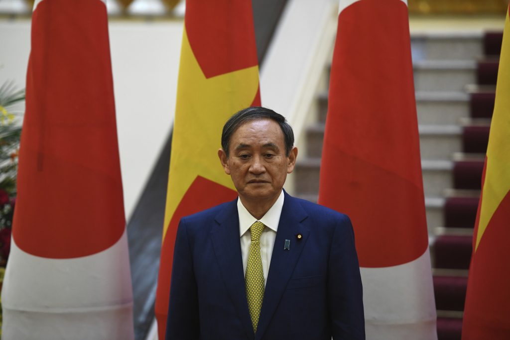 Japan's Prime Minister Yoshihide Suga, with his Vietnamese counterpart Nguyen Xuan Phuc, attends the exchange documents ceremony at the Government Office in Hanoi Monday, Oct. 19, 2020. Suga, in his first summit foray since taking office last month, agreed with his Vietnamese counterpart to step up defense and security cooperation in the face of China's expanding influence in the region. (Nhac Nguyen/Pool Photo via AP)