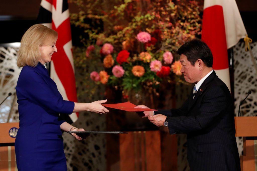 Britain's International Trade Secretary Elizabeth Truss and Japanese Foreign Minister Toshimitsu Motegi exchange documents at a signing ceremony of the UK-Japan Comprehensive Economic Partnership Agreement in Tokyo, Japan Oct. 23,2020. (File photo/Reuters)