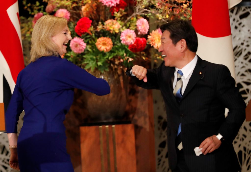 Britain's International Trade Secretary Elizabeth Truss and Japanese Foreign Minister Toshimitsu Motegi bump elbows during their news conference following a signing ceremony of the UK-Japan Comprehensive Economic Partnership Agreement in Tokyo, Japan Oct. 23,2020. (File photo/Reuters)