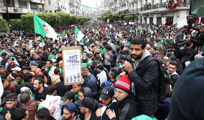 Algerians, waving national flags, march during an anti-government demonstration in Algiers, as the country is readying for a constitutional referendum. (AFP)