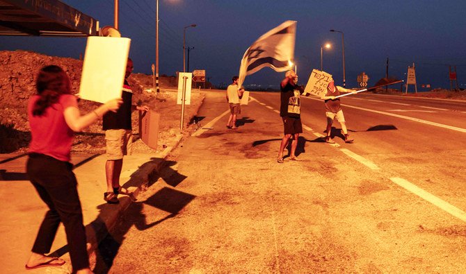 Israeli protesters gather for a demonstration in the Mitzpe Shalem settlement by the Dead Sea in the occupied West Bank on October 8, 2020, against Prime Minister Benjamin Netanyahu's government during a nationwide lockdown to stop the spread of COVID-19 coronavirus disease. (AFP)