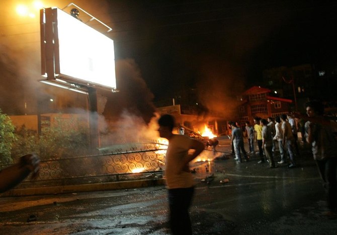 Iranians watch a burning petrol station set on fire by angry Iranians early 27 June 2007 in the northwest of Tehran. (File/AFP)