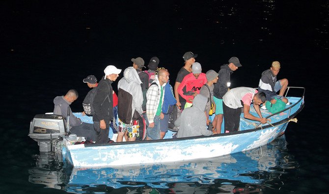 Migrants are seen on a boat as they approach the dock on the Sicilian Island of Lampedusa, Italy July 24, 2020. (REUTERS)