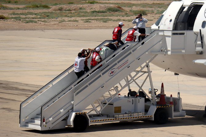 A Houthi prisoner is carried into a plane to be transported to Sanaa airport as he is released by the Arab coalition in a prisoner swap, at Sayoun airport in Yemen on October 15, 2020. (REUTERS/Ali Owidha)