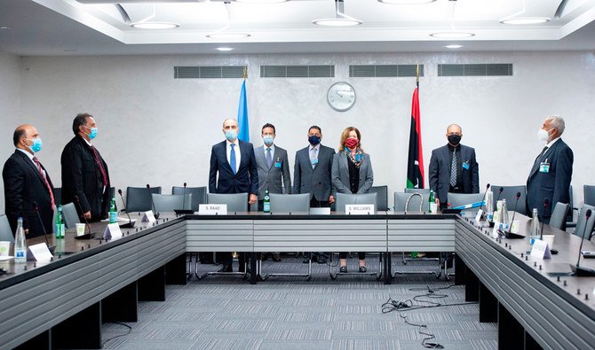This handout picture released on October 19, 2020 by the United Nations Office at Geneva shows Deputy special representative of the UN Secretary-General for Political Affairs in Libya Stephanie Williams (3rd R) and representatives wearing protective face masks, standing during the Libyan national anthem at the beginning of talks between the rival factions in the Libya conflict, as they resume in Geneva. (AFP)