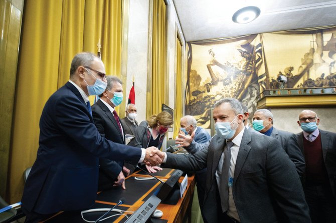 Representatives of Libya’s two rival factions shake hands after signing a ‘permanent’ cease-fire agreement following the five-day talks at the UN. (AFP)