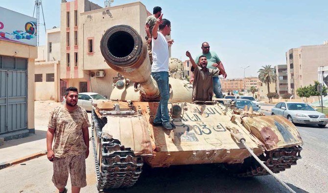 Fighters loyal to the Tripoli-based government stand atop a tank in the town of Tarhuna, about 65 km southeast of the capital of Libya. (AFP)
