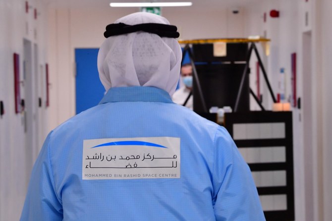An engineer wearing a logo of the Mohammed Bin Rashid Space Centre (MBRSC), walks toward a KhalifaSat model, in the Gulf emirate of Dubai on July 5, 2020. (File/AFP)