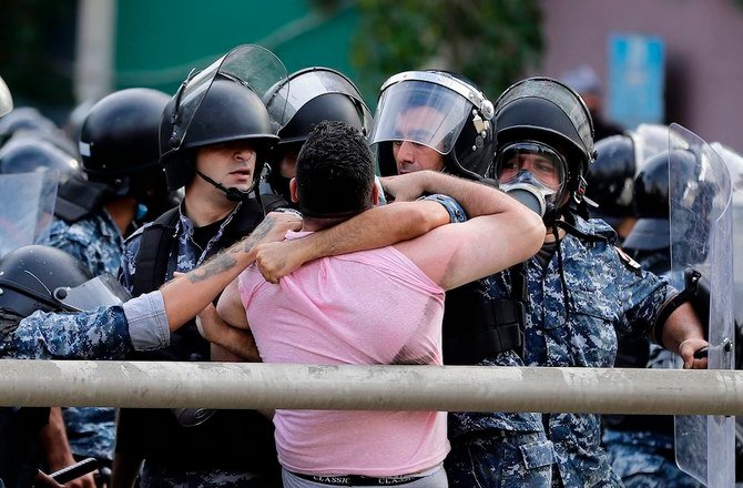 Members of Lebanon's security forces clash with a demonstrator at a rally called by an Islamist group to protest the French President's defence of the right to publish cartoons seen as offensive to Islam, near the residence of the French Ambassador in the capital Beirut, on October 30, 2020. (AFP)