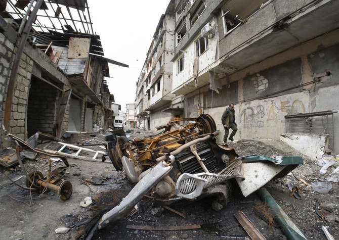 A man walks in the yard of an apartment building damaged by shelling by Azerbaijan's artillery during a military conflict in Stepanakert, self-proclaimed Republic of Nagorno-Karabakh, Wednesday, Oct. 7, 2020. (AP)